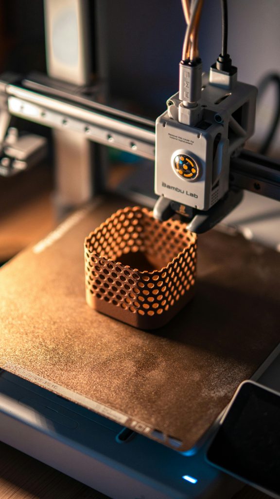 pexels photo 30620861 30620861 Close-up of a 3D printer creating a hexagonal object in a dimly lit workspace.